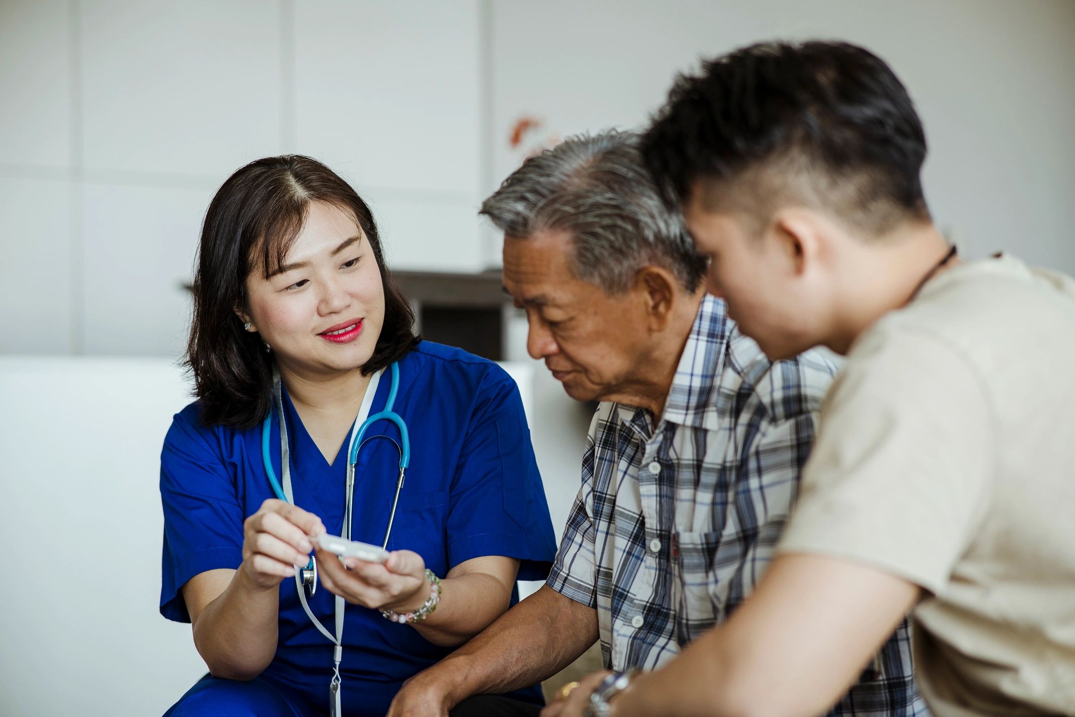 Nurse speaking with senior patient and family member